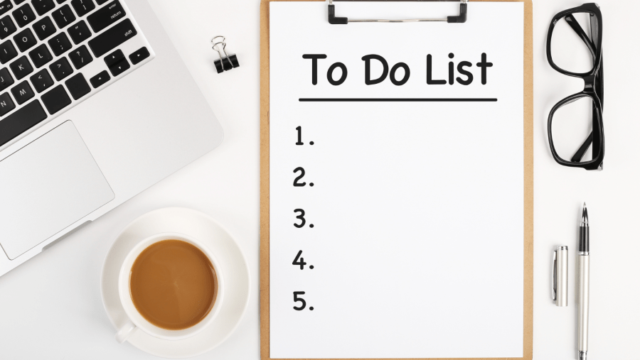 an image of a desk with laptop, glasses, pen and To do List